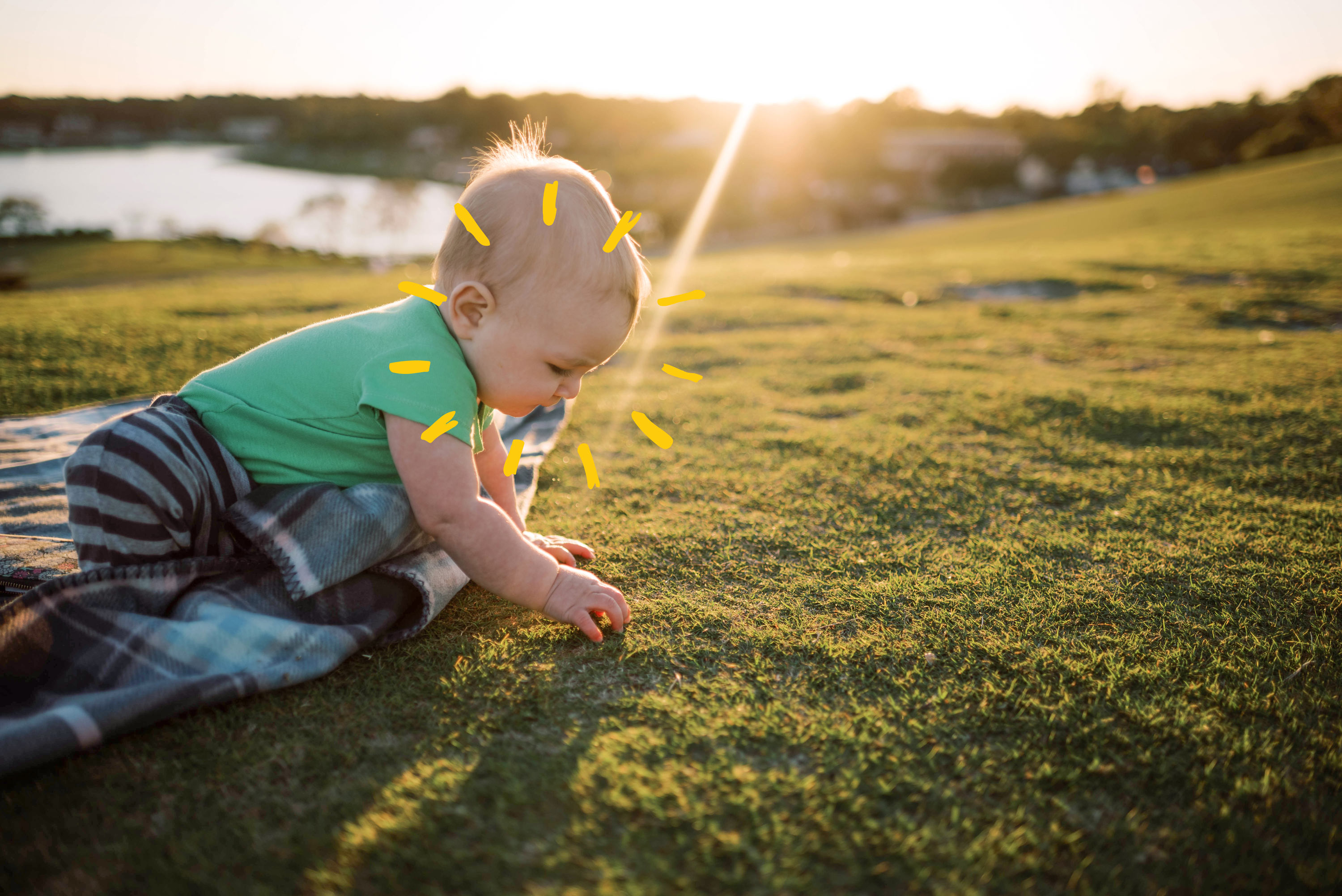 Baby playing i grass with sunshine